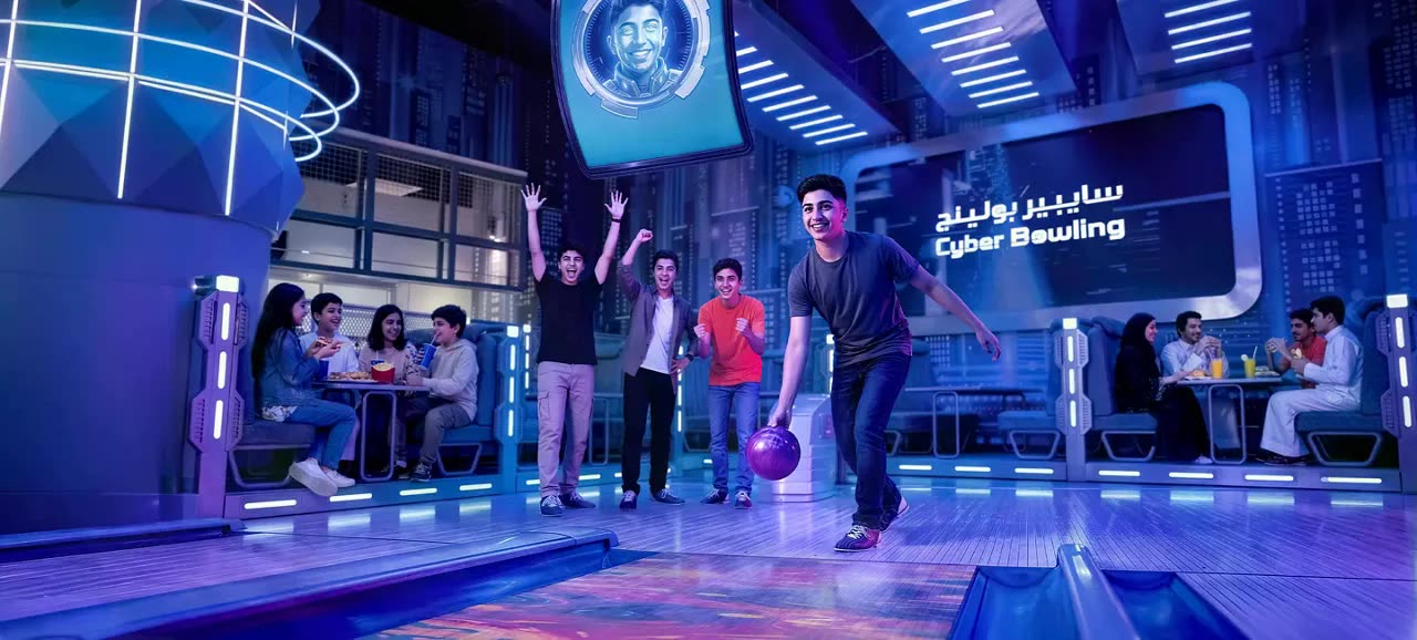 Cyber Bowling lanes lit in blue and violet, guests mid-game
